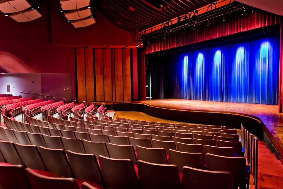 Rows of empty seats in the Gordon Center curving towards the lit stage.